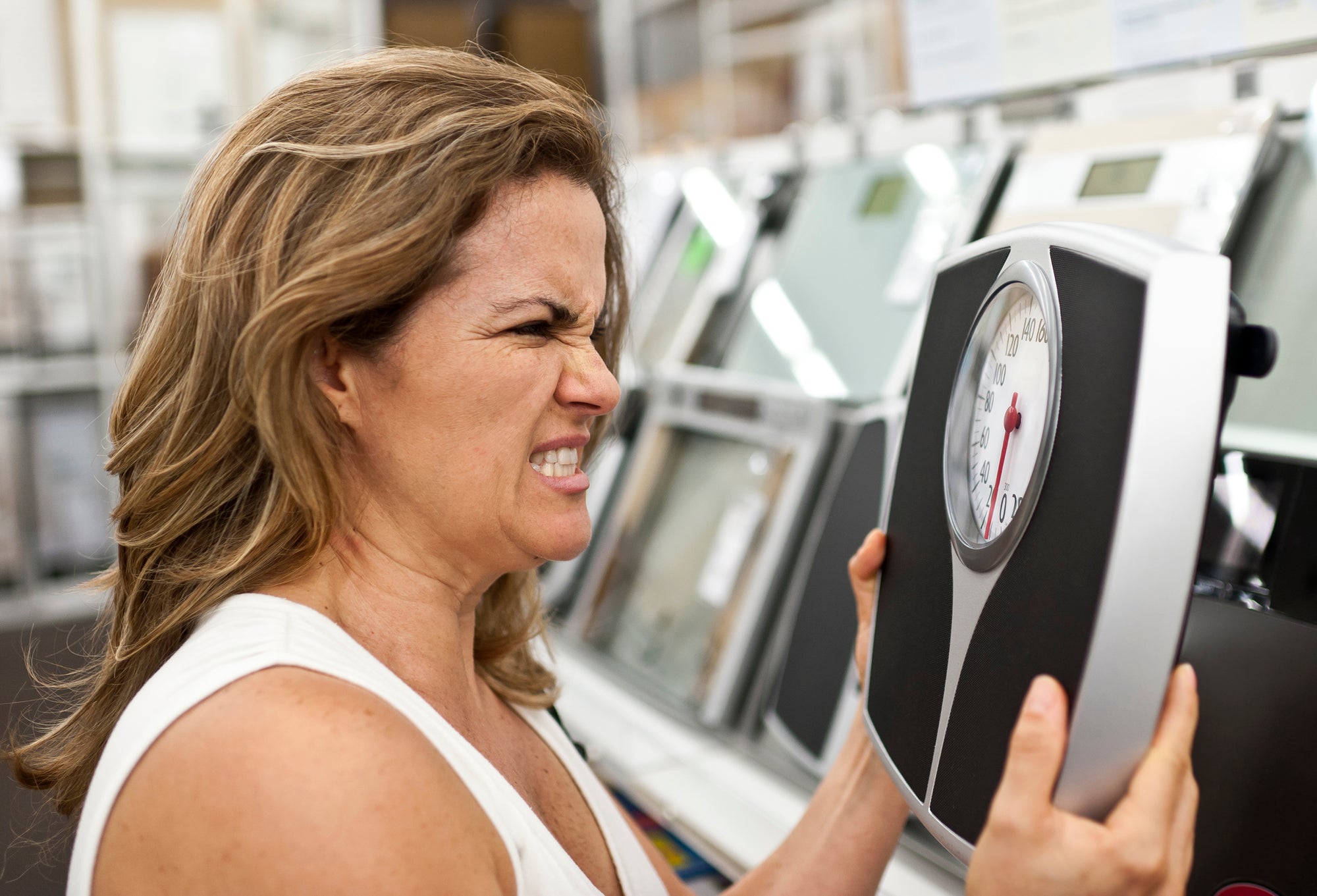 Stressed woman is angry at her scale