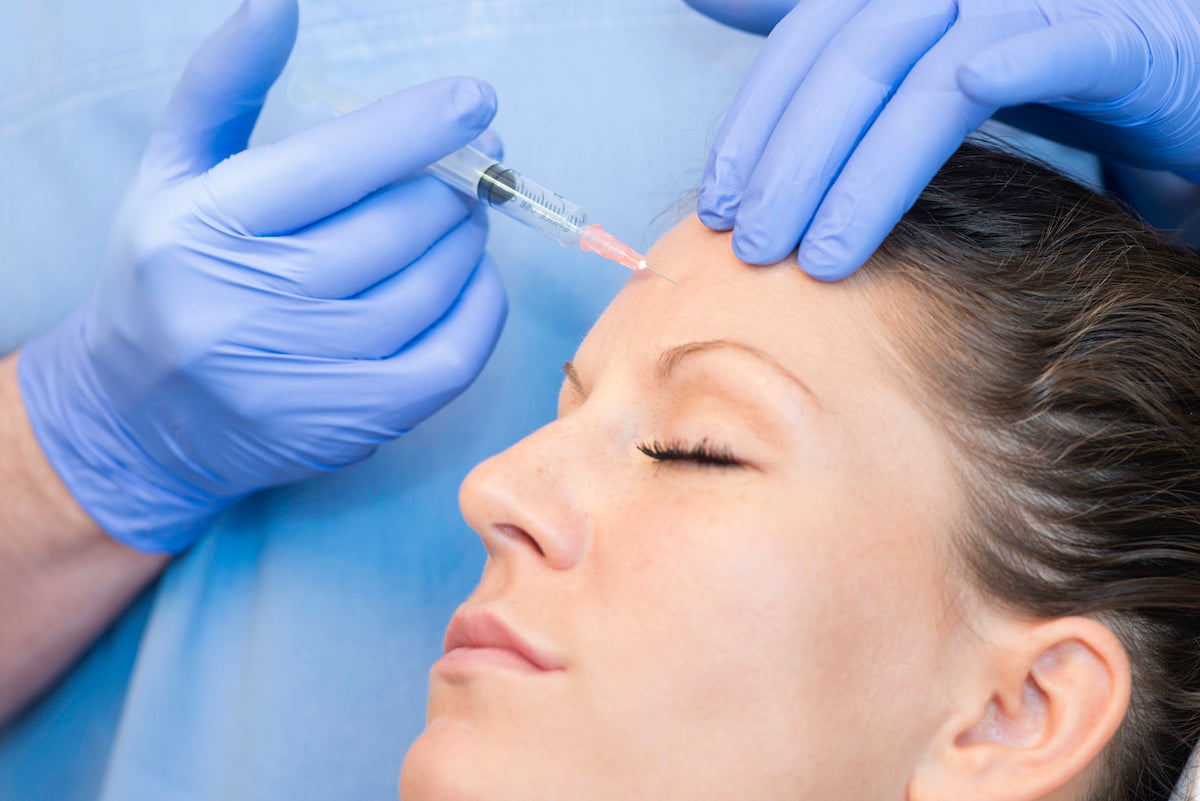 Women receiving botox in the forehead