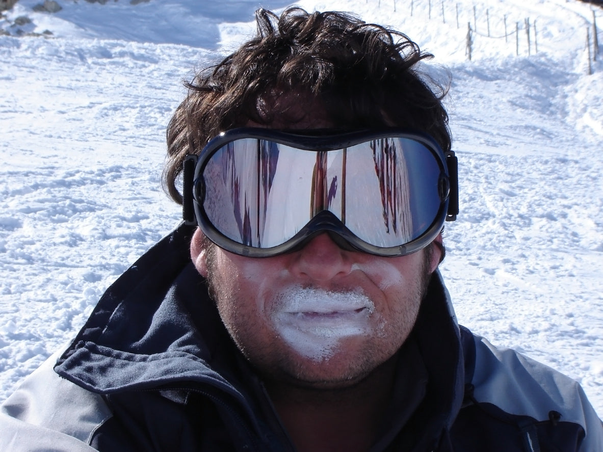 man with ski goggles and white sunscreen on lips